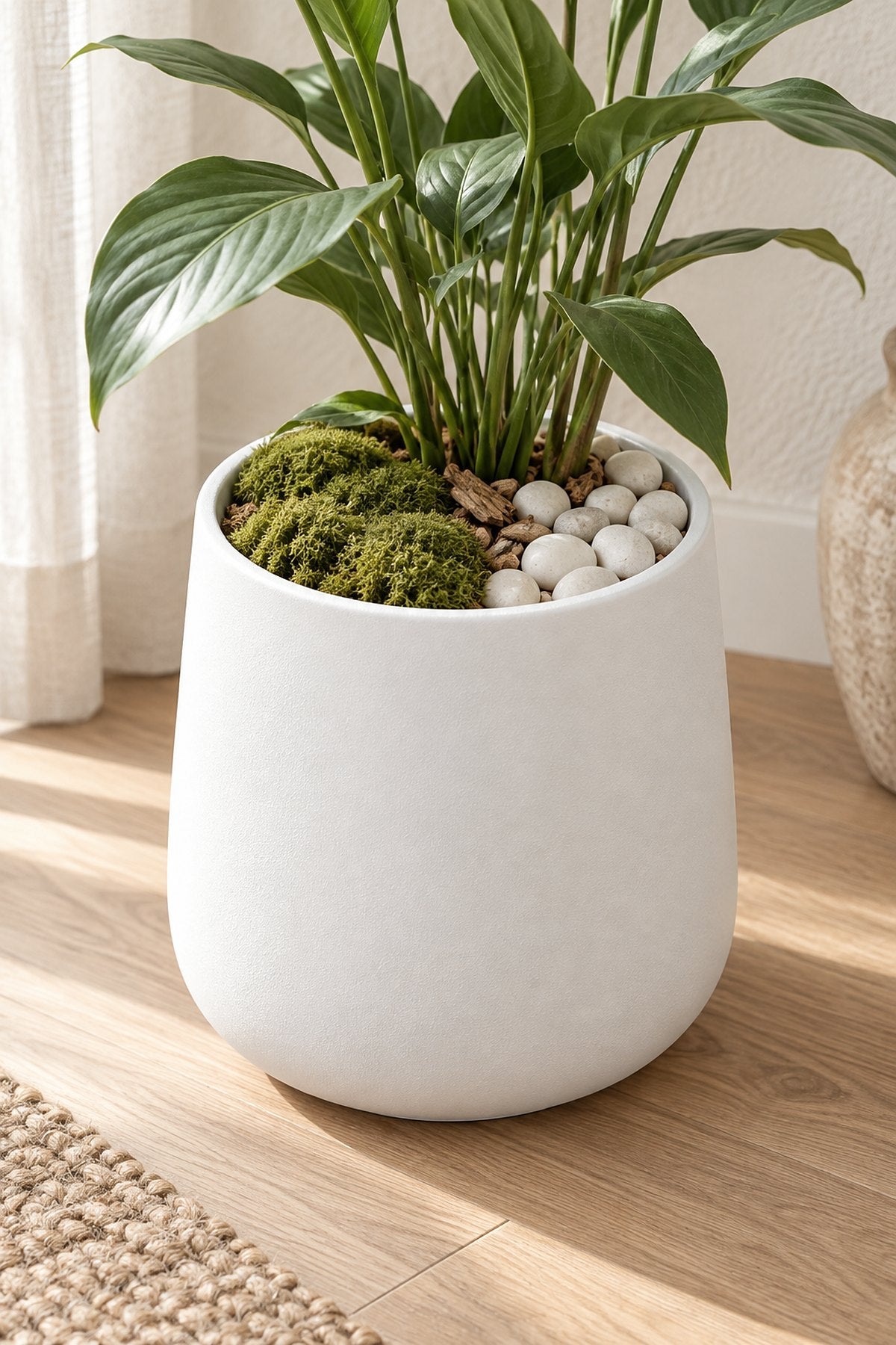 Preserved moss and white pebbles covering the top of a white planter